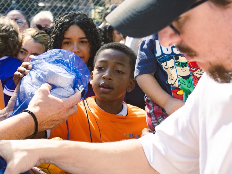 Niño recibiendo guayos donados