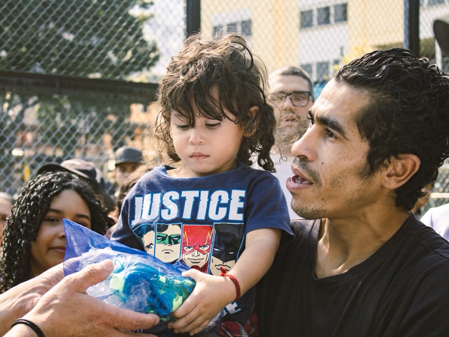 Niño recibiendo un par de guayos donados en La Guayatón